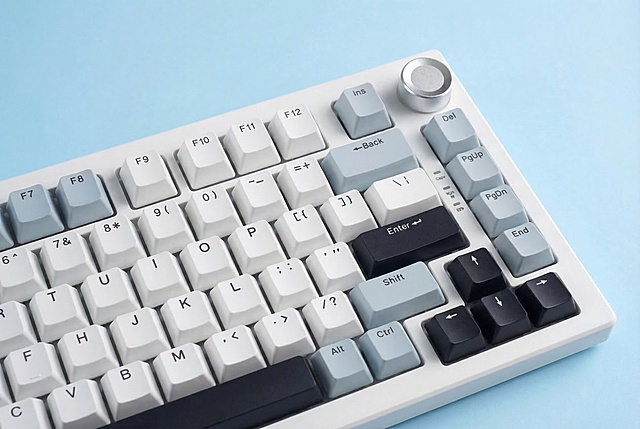 将图1键盘的配色替换为图2键盘的配色：F8、Ins、Back、Alt、Fn、Ctrl、右侧功能区侧键（Del/PgUp/PgDn/End）为浅灰蓝色，F9-F12、字母/数字/符号键为白色，Enter、方向键、空格键为黑色，键盘外壳为白色，保持图1的浅蓝色背景、斜拍构图、光影、键盘位置完全不变