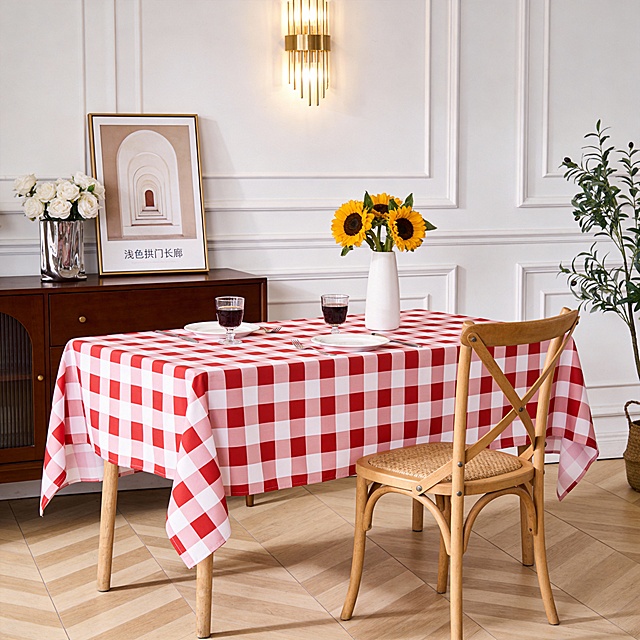 生成一处温馨优雅的居家餐厅场景，整体风格偏向轻法式简约风，氛围柔和舒适：长桌上铺着桌布（如参考图），质感柔和精致；桌上摆盘整洁：中间是插着向日葵的白色花瓶，，还有两只盛着深色饮品的玻璃杯，以及配套的白碟、餐具，细节显得精致又有生活气息。餐桌旁是浅木色椅身 + 编织坐垫的椅子，复古简约；桌侧的深木色柜子上，摆着银色花瓶（插着白色花束）与一幅 “浅色拱门长廊” 装饰画，风格清新；背景是带线条装饰的白色护墙板，墙上的金色壁灯已点亮，暖光增添了温馨感；右侧还露出绿植一角，让空间更有生机。浅木色人字拼木地板色调温暖，和家具风格统一；整体光线柔和，布置精致却不刻意，像是为用餐 / 下午茶准备的舒适场景，既优雅又有生活的松弛感。