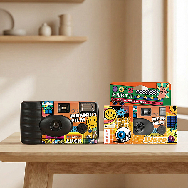 这是一款可以定制的一次性胶片相机，换个背景图，但是不要纯色，要简约的款式，相机的款式不要变，相机挨着外包装盒，类似于在室内的背景图，把相机放在桌子上，画面要协调，视觉中心是相机，虚化背景，主次要分明，要第一眼就看到相机，把相机整体都呈现出来，外包装盒也要全部露出来