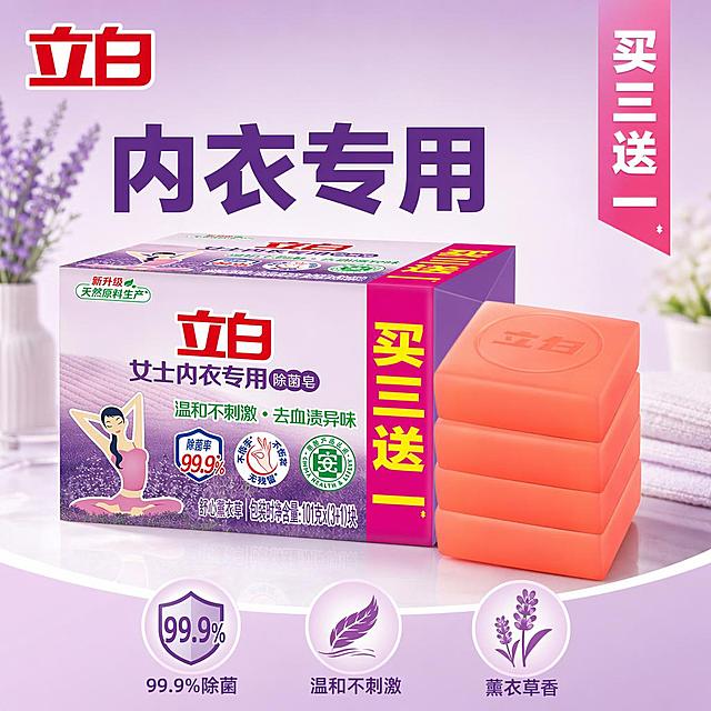 [主图-1] 立白女士内衣专用除菌皂首图，买赠价值首图，展现洁净囤货吸引力。
[氛围风格] 干净清新家居风，突出洁净感和实用感
[画质] 商业摄影质感、光线柔和通透、产品清晰真实、画面干净高级。
[元素] 立白内衣皂包装盒搭配四块橙红色皂块整齐堆叠，放在画面居中位置，包装盒完整呈现，四块肥皂堆叠在包装盒右侧，清晰展示买三送一的促销内容。保持产品外包装颜色、图案、文字信息和肥皂颜色、形状与输入产品图绝对一致，杜绝任何变形和色差，精细化处理产品纹理。商品主体占比严格控制在65%左右；画面满屏无边框。左上角安全位置保留立白品牌Logo，保持原有字形和配色不改变。
[光影] 明亮柔和的顶侧自然光，包装盒和肥皂形成自然柔和高光，底部投下淡淡的轮廓阴影，整体通透不灰蒙，高光不溢出，暗部有层次，真实干净的商业摄影质感。
[配色] 主色调浅紫搭配暖橙色，提取原产品包装紫色和肥皂橙色，背景采用浅紫渐变到白色，干净清新，符合女性洗护产品调性。
[视角构图] 平视视角，产品居中，景深中等，产品完整不裁切，视觉重心稳定。
[文字版式] 左侧大标题写"内衣专用"，右侧粉色竖条写"买三送一"，底部三列卖点，依次为"99.9%除菌 温和不刺激 薰衣草香"，大标题粗体最大，促销文字醒目，卖点文字清晰，所有文字不遮挡产品主体，字色与背景强对比，文字占比小于30%，符合规范。
[输出要求] 1:1比例，文字清晰锐利，画面超高清商业摄影质感，参数为width=1024 height=1024
[负向提示词] 变形，文字错乱，产品图模糊，背景杂乱，水印，电商平台Logo