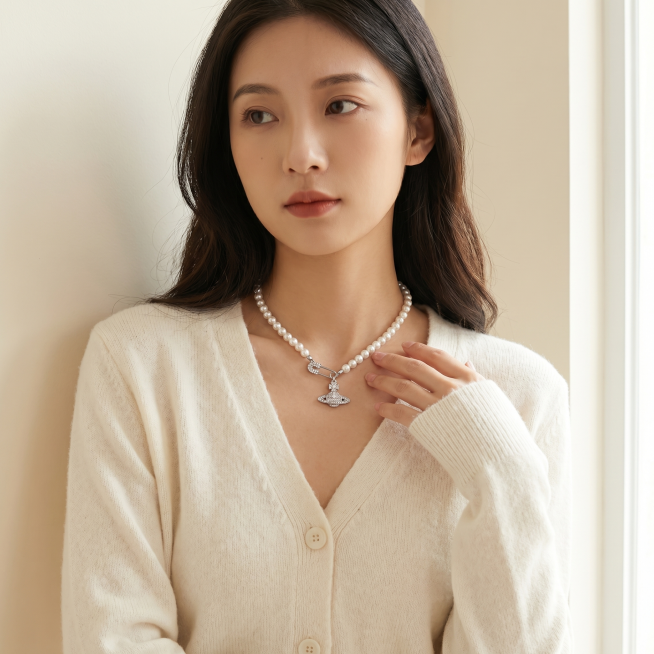 [主图 2] 年轻亚洲女性佩戴西太后满钻土星珍珠锁骨项链中景展示。[氛围风格] 高级温柔氛围感，生活化时尚实拍风。[画质] 商业摄影质感、光线柔和通透、产品清晰真实、画面干净高级。[元素] 同一位年轻预览效果