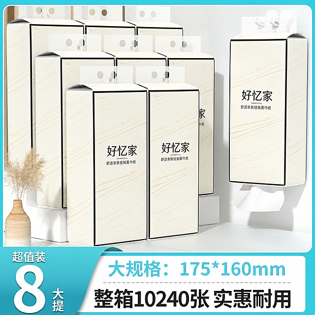 将图中所有悬挂式抽纸外包装的图案完全替换为参考白底图（image_urls中第一张）的包装设计：米白色底色配金色流线纹理，正面中央有黑色'好忆家'大字，下方有'HEREFFUL'英文和'舒适亲肤挂抽面巾纸'中文，包装边缘有黑色细边框。保持产品的悬挂式抽纸形态、数量、排列方式、底部抽出的纸巾、背景环境（白色墙面、干花装饰、花瓶）、底部促销文字和价格信息全部不变。包装图案要完全迁移，注意细节准确，文字清晰可读，透视角度正确。