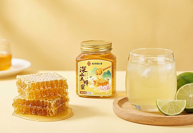 画面中央是南京同仁堂品牌的“深山土蜂蜜”，透明琥珀色瓶身装有金黄色蜂蜜，金色金属瓶盖，瓶身标签有蜜蜂、蜂巢、花朵、青山插画，标注500克。瓶子左侧放置切开的天然蜂巢，表面滴落蜜汁；右侧是一杯盛有带冰块的淡黄色蜂蜜饮品的玻璃杯，旁边摆放几片新鲜青柠。整体为柔和暖黄色调背景，光线明亮均匀，营造温暖健康自然的氛围，突出蜂蜜纯正高品质