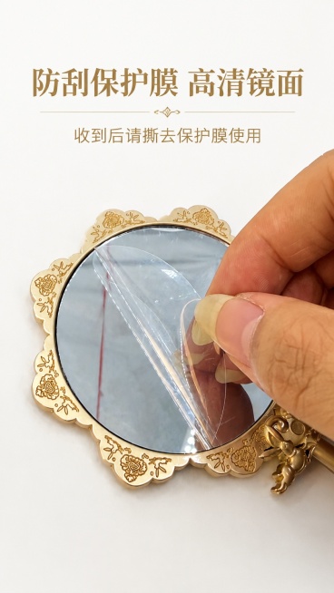 [第5屏] 使用提示，敦煌手持化妆镜镜面保护膜设计展示。本屏使用【图8】作为展示主体。
[氛围/风格] 清晰操作说明，简洁直观，真实操作感。
[元素布局] 保留原图手撕保护膜的操作动作，展示圆形镜面花预览效果