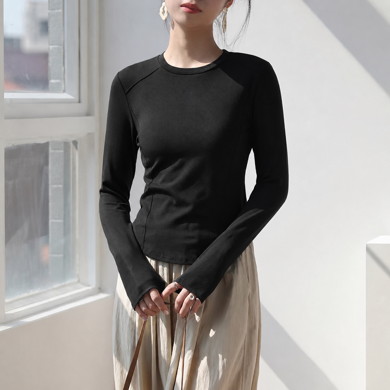 将图中人物的长袖上衣改为纯黑色，保持衣服的版型、褶皱、光影质感… - 图片创意预览