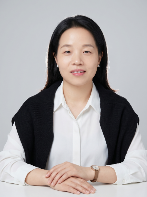 以上传的照片人物为原型，保持参考图中人物形象不变，黑发柔顺自然，皮肤细腻透亮可见自然肌理，清透伪素颜妆淡粉唇干净底妆，佩戴简约方形耳饰与细带腕表，身穿白色翻领衬衫+黑色针织披肩，浅灰纯色简约背景，棚拍预览效果