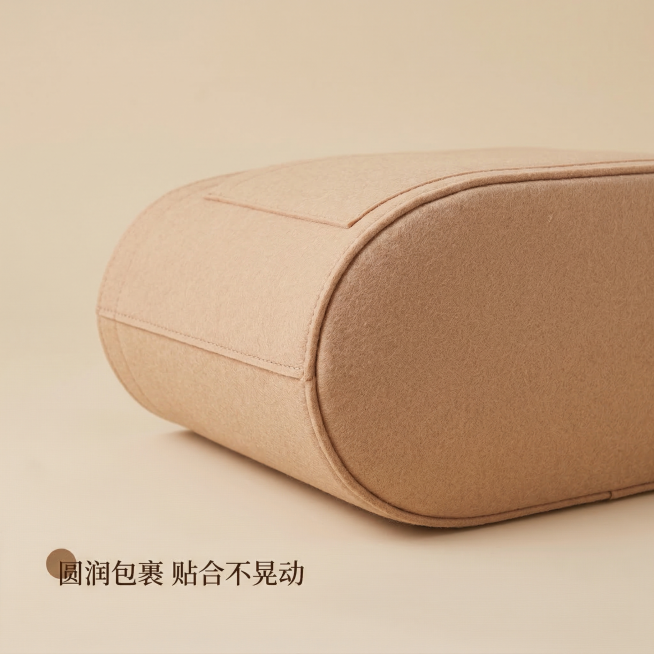 蔻驰MOLLIE托特包内胆包，主图主题：圆润包裹弧度展示，氛围风格：舒适简约 家居治愈，画面元素：侧视角展示内胆包圆润包裹式底部弧度，贴合包底不晃动，放置在浅米色背景上，柔和光线凸显轮廓，整体整洁干净预览效果