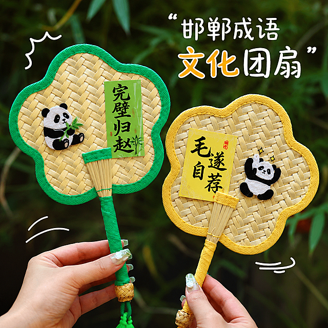 参考原图风格，重新生成两把竹编团扇，团扇换成邯郸成语文化主题内容，保留竹编材质、熊猫刺绣、文字贴纸、手持拍摄风格和户外绿植背景