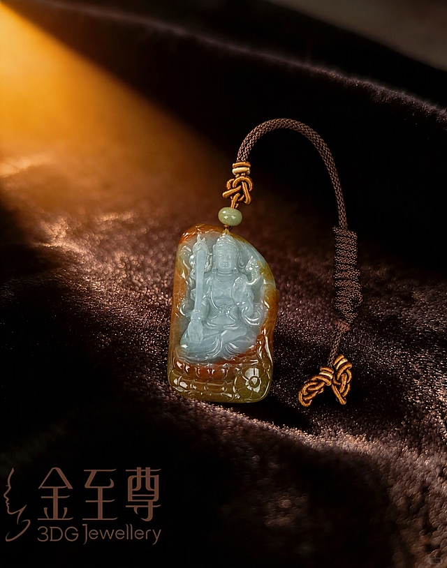 将图一中的三件黄金珠宝全部移除，保留深棕色丝绒布背景、暖金色光影效果和左下角的'金至尊 3DG Jewellery'logo文字不变。把图二中的翡翠观音吊坠（含挂绳、顶珠和绳结）完整抠出，保持翡翠原有的冰透质感、红翡俏色、雕刻细节和绳结样式完全不变，将吊坠自然摆放在图一的丝绒布上，位置居中偏下，角度与画面视角协调，光影与原图暖金色环境光一致，投射自然柔和的阴影，整体画面真实自然，融合无缝，高端珠宝摄影质感