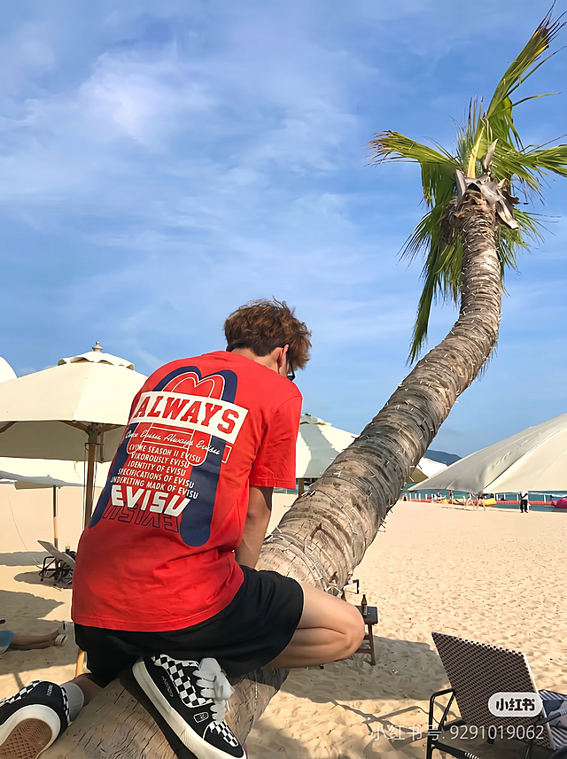 保留模特姿势和背景，将模特身上的衣服替换成图1的红色EVISU印花T恤，保证图案完整呈现，衣服自然合身
