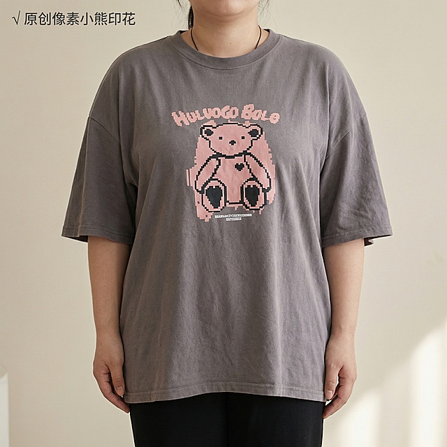 [主图主题] 女士宽松短袖T恤 小熊印花细节展示
[氛围/风格] 韩式慵懒休闲风，柔和自然光，细节质感清晰
[画面元素] 亚洲女性模特（与原图一致）身着灰色宽松短袖T恤，近景特写T恤胸前的粉色像素小熊印花，清晰展示印花细节和工艺，下装保持黑色长裤不变，背景为浅米色纯色背景。
[配色色系] 主色调：浅米灰背景；辅助色：T恤灰色，粉色小熊印花
[视角构图] 胸部特写平视，印花占画面主体位置，景深适中
[文字版式] 左上角小字“√ 原创像素小熊印花”，字体深灰色无衬线，轻盈不遮挡印花细节
[比例分辨率] 2k分辨率