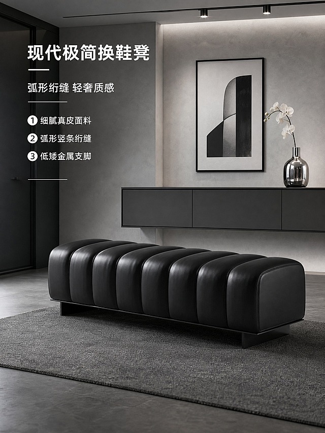 将背景替换为现代极简入户玄关场景，产品保持原样不变，侧面视角（从右侧面拍摄），接近人眼平视高度，高级冷调氛围，重点展示侧面弧形竖条造型与金属脚结构。

场景：现代极简入户玄关，深灰色微水泥地面（哑光细腻质感），浅灰色艺术漆墙面（带微妙肌理质感），背景是极简悬浮式玄关柜（深灰色哑光柜门，无拉手设计，极窄黑色金属边框），柜面放一个银色金属花瓶插着一枝白色兰花。墙面挂一幅黑色细画框的极简黑白抽象装饰画。顶部有嵌入式磁吸轨道灯，冷白光照明。地面铺一块深灰色短绒地毯。整体空间干净利落，高级冷调，现代极简风格。

产品：黑色弧形竖条绗缝换鞋凳，保留原图的所有结构、材质、颜色、比例，包括黑色细腻真皮圆弧软包坐垫（8道弧形竖条绗缝，饱满圆润）+低矮黑色金属脚（L形截面，前后各两个）。真皮细腻有光泽，弧形竖条饱满立体，缝线精致工整，黑色高级沉稳。侧面视角重点展示侧面弧形竖条排列造型与低矮金属脚结构。

文字卖点：左上角有主标题"现代极简换鞋凳"，副标题"弧形绗缝 轻奢质感"，下方3个亮点：① 细腻真皮面料 ② 弧形竖条绗缝 ③ 低矮金属支脚。文字为白色粗体无衬线字，配银色细下划线装饰，文字清晰不遮挡产品。

整体风格：商业家具效果图，高级冷调，空间干净利落，现代极简风格，2K高清。