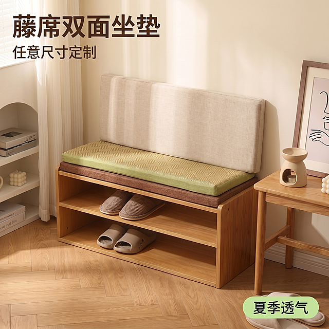 [主图 1] 藤席双面定制坐垫换鞋凳场景首图，展示坐垫放置在原木换鞋凳上的完整效果。
[氛围风格] 温馨原木风家居生活感；
[画质] 商业摄影质感、光线柔和通透、产品清晰真实、画面干净高级。
[元素] 保持藤席双面坐垫外观（物理结构、材质质感、颜色）与输入产品图绝对一致，杜绝任何变形和色差，精细化处理。坐垫整体平铺于原木换鞋凳居中位置，商品主体占比约70%；背景为浅米白墙面、人字拼浅原木地板，左侧白色置物架摆放书籍和装饰球，右侧原木边几搭配香薰摆件和装饰画，前景地面摆放一双米色拖鞋，软装丰富不抢主体，画面满屏无边框。
[光影] 白天侧向自然光透过白色纱帘，形成柔和漫射光影，色温暖调；藤席和亚麻材质纹理清晰呈现，高光不溢出，暗部有层次，整体通透不灰蒙。
[配色] 主色调为原木浅黄、藤席草绿、亚麻米黄；辅助色为浅白墙面，整体清新自然。
[视角构图] 四分之三平视角度，以坐垫和换鞋凳为视觉中心，前景中景后景分层，景深适中，产品轮廓完整不裁切。
[文字版式] 左上负空间左对齐留安全边距，大字主文案写"藤席双面坐垫"，深棕色最大号粗体无衬线字体；下方小字号副文案写"任意尺寸定制"，约一半大小，同色系略浅；右下角浅绿色圆角标签标注"夏季透气"，文字深绿，大小适中。文字不遮挡主体。
[比例分辨率] 1:1 比例，2k 分辨率；文字清晰锐利，画面超高清。
[负向提示词] 变形，水印，文字错乱，产品图模糊，背景杂乱，文字遮挡主体