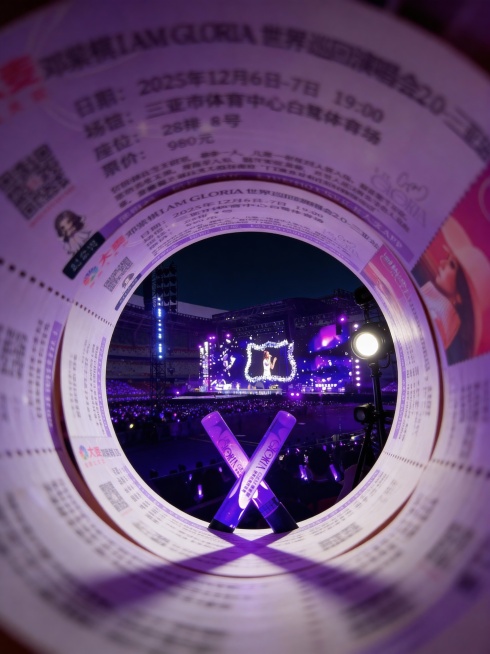 把图1的演唱会门票卷成隧道形状，通过圆形洞口呈现透视效果，强纵深感。隧道尽头展示图2的演唱会现场场景。固定聚焦在演唱会场景上，周围呈现朦胧模糊、拖影的效果。预览效果