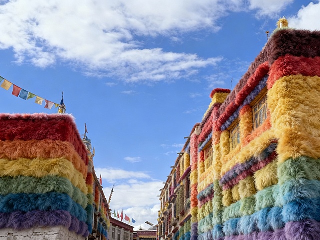 建筑整体呈现出全毛绒质感的风格，毛绒有层次感，毛绒颜色为彩虹色调。建筑保留原始形状，各个部分都如同被几种颜色柔软的毛绒材质精心包裹