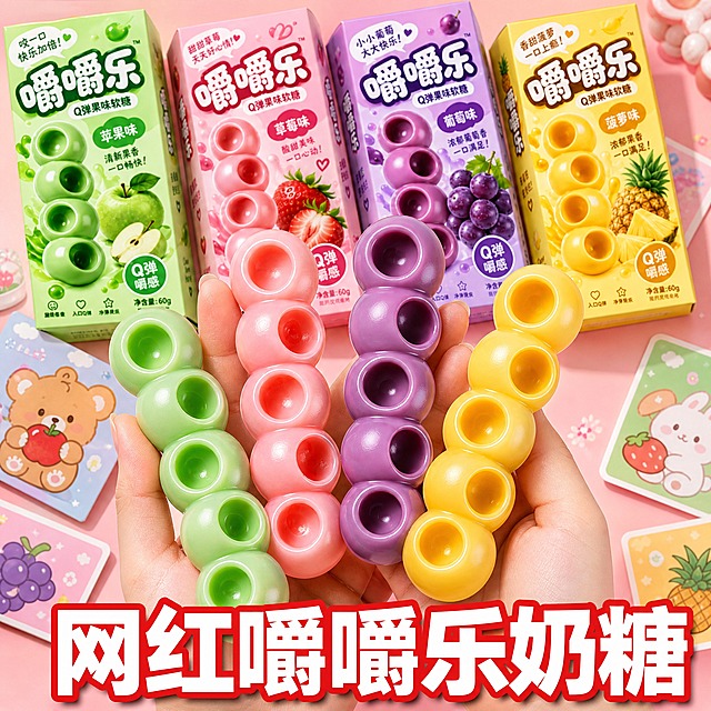 电商主图，1:1正方形，爆款促销感风格。保留参考图的版式与文字位置：画面中央偏上为双手手持展示产品的构图，底部居中放置超大主标题文字。将原参考图中的软糖产品全部替换为新产品图中的嚼嚼乐奶糖：包含苹果味（绿色）、草莓味（粉色）、葡萄味（紫色）、菠萝味（黄色）四种口味的串状Q弹软糖，以及对应口味的四款包装盒，产品外观、颜色、结构、包装设计必须与输入产品图完全一致。双手从画面下方托举多根不同口味的嚼嚼乐软糖，软糖呈糖葫芦串造型，Q弹圆润有光泽，表面光滑带高光，体现软糯弹牙的质感。背景为温馨可爱的浅粉色渐变桌面，背景中散落摆放着四款口味的嚼嚼乐包装盒和可爱的卡通小卡片，营造网红零食氛围。底部居中用超大粗黑体白色字配红色描边写主标题："网红嚼嚼乐奶糖"，字体醒目有冲击力。整体画面明亮通透，暖色调柔光，食欲感强，商业摄影质感，产品清晰完整不被遮挡。