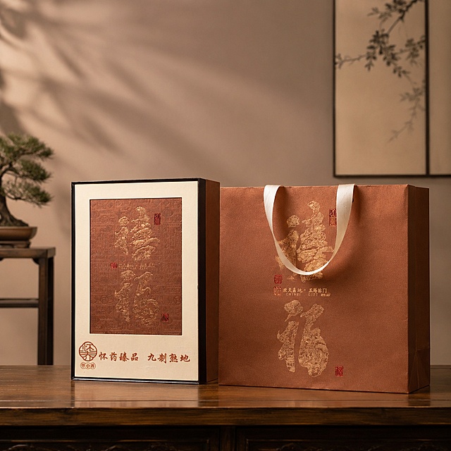 超写实商业礼品摄影。
主体：咖色熟地礼盒和咖色手提礼袋严格参照上传产品图，完整保留所有组件、轮廓、结构、比例、材质、颜色与产品本体上的文字信息（logo/浮雕/文字等），与上传图完全一致。产品为第一视觉焦点，完整展示不裁切。
构图：居中平视构图。
风格：新中式极简商务摄影。
场景：极简风中式客厅，商务伴手礼品静物展示场景。
空间承载：①原木茶几，咖色礼盒平稳摆放茶几中央；②同色系咖色手提袋置于礼盒一侧；③背景，简约素净墙面，点缀中式小摆件，背景层次简洁干净。
配色/材质：咖棕/原木色/浅米/金红；皮革/实木/烫金。
光影：低饱和暖调室内光线，主光柔和打亮礼盒正面，凸显礼盒皮革肌理与烫金文字细节，格调内敛高级，无强烈阴影。
严格锁定宽高比为1:1。