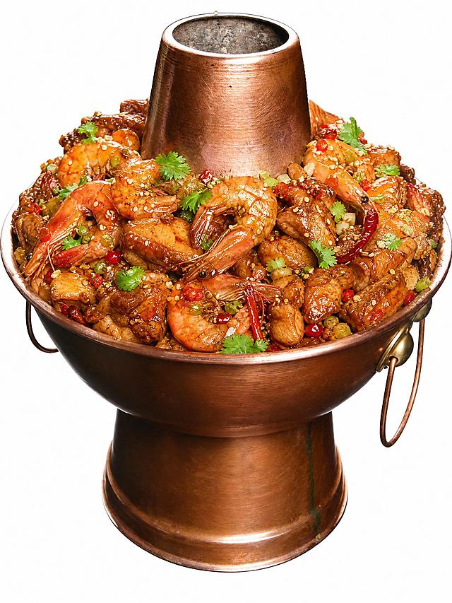 将铜锅中的鸡肉换成鸡虾混合锅，保留部分鸡肉块的同时加入鲜虾、大虾食材，虾要饱满诱人，与鸡肉均匀混合，保持原有的红烧酱汁、芝麻、辣椒、香菜点缀，铜锅和整体构图风格保持不变，真实美食摄影风格，色泽红亮诱人