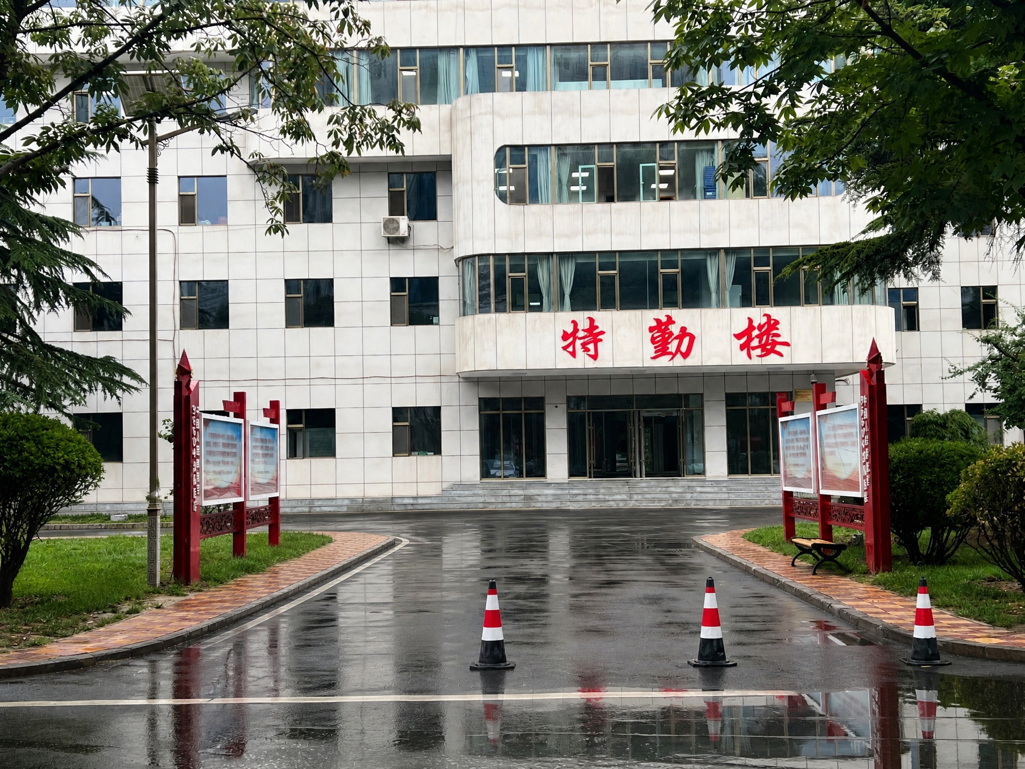 去掉图中所有汽车，保留建筑、树木、道路、交通锥、宣传栏等其他所… - 图片创意预览