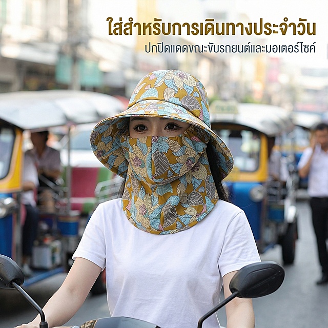 严格还原上传的产品图，包括姜黄色主体、灰蓝色植物印花、一体式连面罩结构等所有细节，产品尺寸帽檐宽约17cm，整体帽深20cm，面罩长度覆盖至下颌，尺寸比例1:1。东南亚生活化清新风格，杂志级居中人物排版，30岁东南亚自然肤色女性模特佩戴产品骑乘摩托车，背景为泰国曼谷街头通勤场景虚化；主标题泰语「ใส่สำหรับการเดินทางประจำวัน」置于画面右上侧粗体，副标题泰语「ปกปิดแดดขณะขับรถยนต์และมอเตอร์ไซค์」置于主标题下方细体，文字配色贴合产品色调，整体自然真实，风格统一无割裂。
