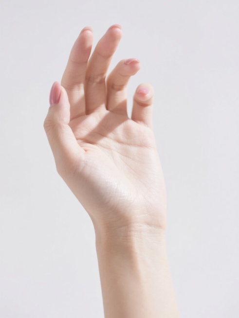 一只女性的手，手部皮肤细腻白皙，指甲修剪整齐并涂抹着自然的裸粉色指甲油，手腕线条优美，手背有轻微的自然纹路和光泽感，手掌呈自然放松状态向上摊开，五指微微分开，整体姿态优雅自然，背景为纯白色，光线明亮柔和，突出手部的细腻质感和自然美感。预览效果