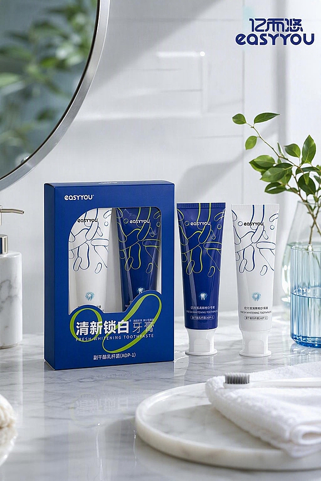 基于图中的亿而悠easyyou牙膏产品，生成高级感场景化海报，像真实摄影实拍图一样，高清质感。画面以两支牙膏和产品包装盒为主体，放置在简约高级的洗漱台或大理石台面上，搭配柔和的自然光和少量绿植、水杯等生活化道具点缀，营造清新高端的家居卫浴场景氛围。整体色调干净清爽，蓝白为主，光影柔和有层次，产品细节清晰，质感高级。文字很少，只保留品牌logo和极简点缀文字，不要多余文案。