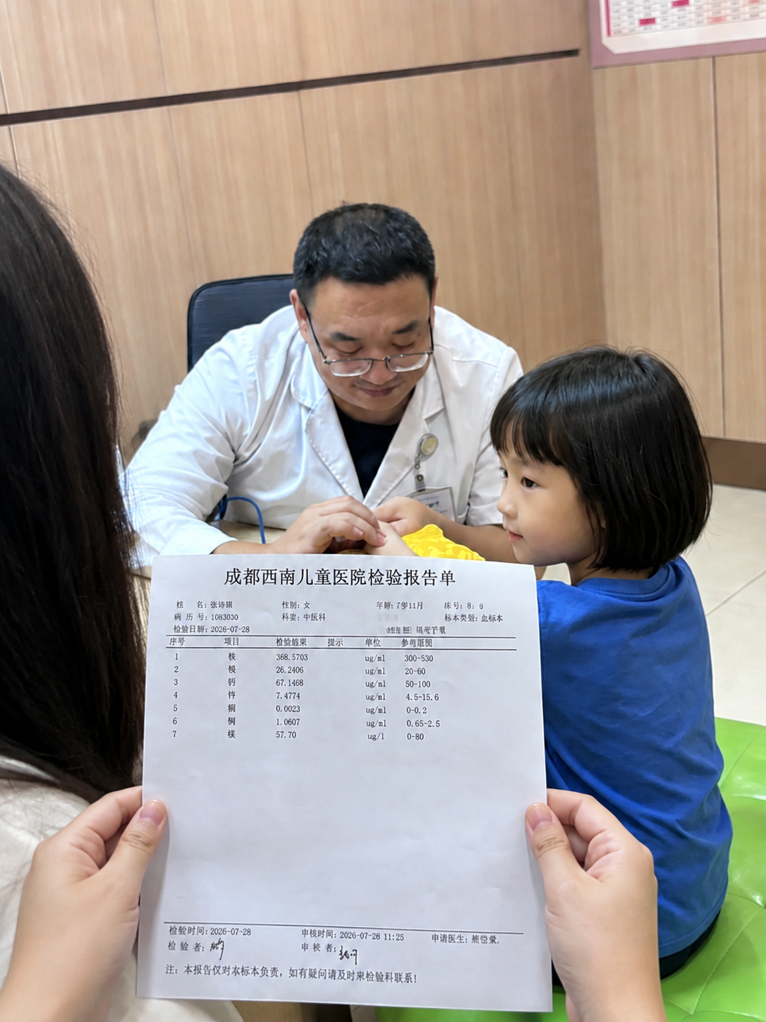 保持图中白衣女性、小女孩、医生以及诊室背景完全不变，在画面最前… - 图片创意预览