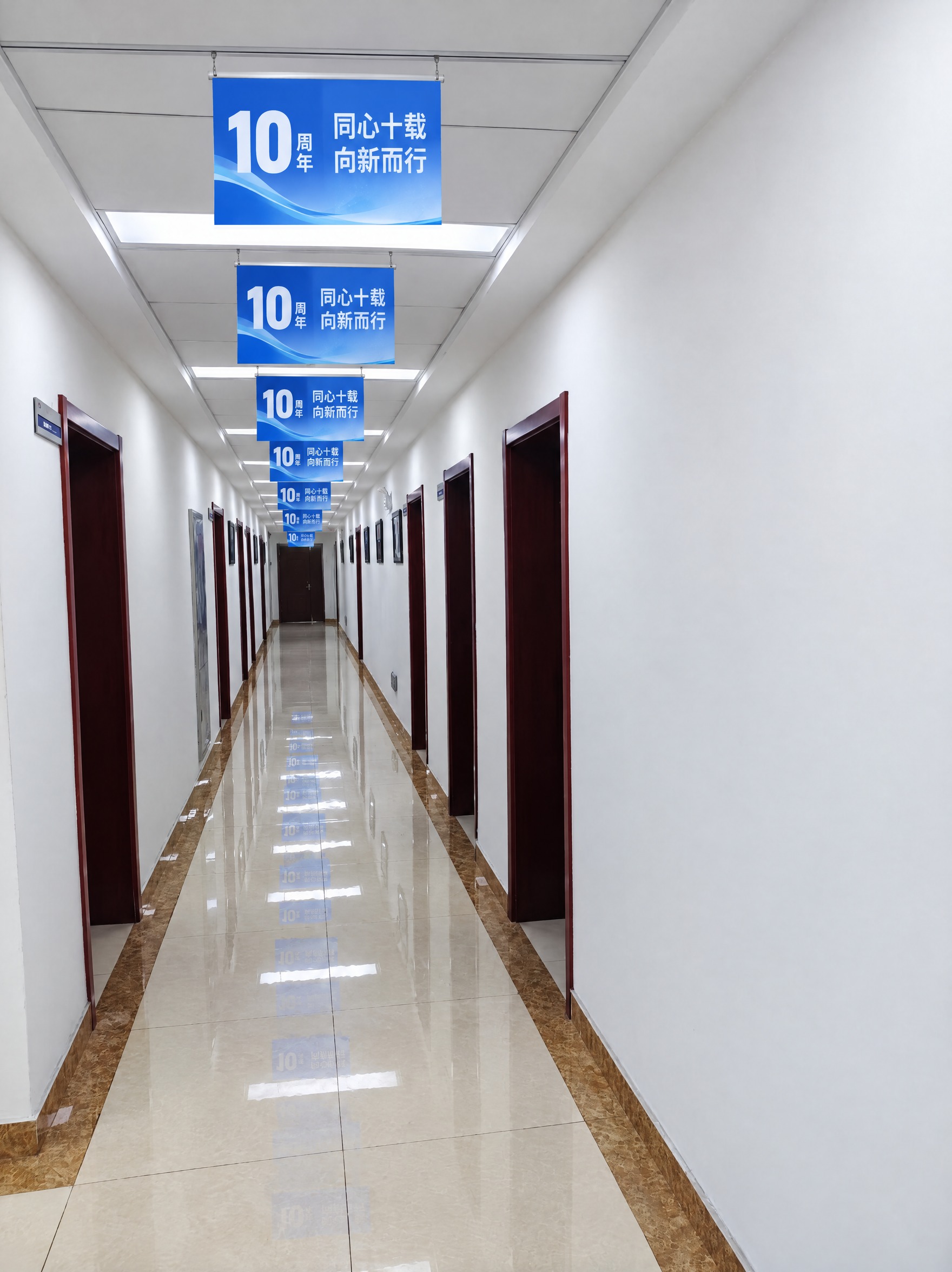 在2楼办公室走廊的天花板下方，沿着走廊纵深方向悬挂一整排蓝色吊… - 图片创意预览