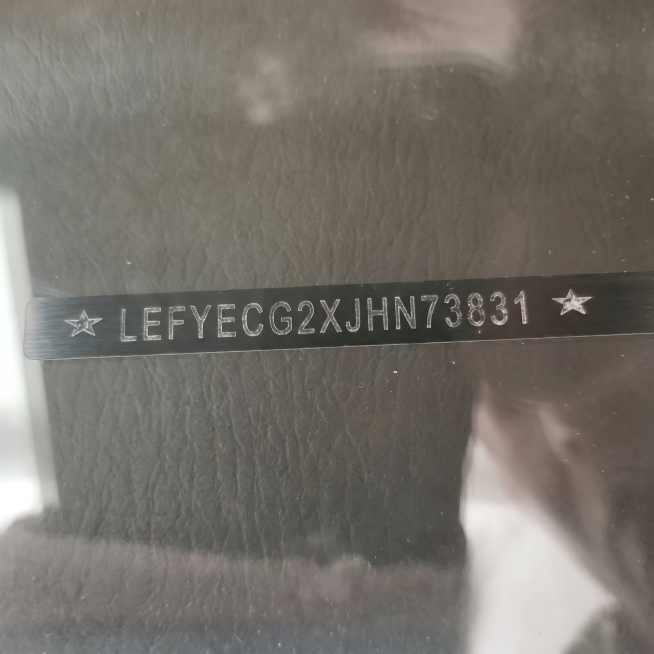 将图片中黑色长条上的文字修改为 ★ LEFYECG2XJHN73831 ★，保留两侧的星星，保持原图片的金属质感、灰色背景和整体风格不变。预览效果
