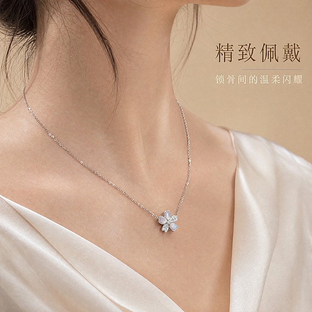 [主图-3] 樱花贝母镶钻银项链 佩戴效果展示 突出上身美感与精致氛围。
[统一基调] 整体风格精致轻奢 柔光质感 背景为浅香槟色丝绒材质 标题字色为深香槟金 辅助字色为米白色 强调色为珍珠白 字体为纤细优雅的衬线体 字号层级分明 无厚重边框 整体克制高级。
[画面] 女性颈部局部特写 佩戴樱花贝母镶钻银项链 模特肤色白皙 颈部线条优美 穿着米白色真丝上衣 领口微露 项链贴合锁骨位置 吊坠正好落在锁骨中间 樱花造型清晰可见 贝母在光线下有温润虹彩 钻石微微闪耀 链条纤细精致 视角为正面微侧45度 聚焦项链与颈部区域 肩部以上虚化 背景为浅香槟色纯色背景 柔和过渡 产品佩戴效果自然真实 无悬浮感。
[光影质感] 人像珠宝摄影质感 柔和侧前方主光 颈部皮肤质感细腻 项链金属与宝石光泽自然 贝母虹彩柔和 钻石有细微火彩 整体光影温柔高级 皮肤无瑕疵 项链无灰尘。
[配色] 背景浅香槟色渐变 模特肤色白皙 米白真丝上衣 项链亮银色+贝母白 文字深香槟金 整体色调温暖统一。
[文字版式] 画面右上角 主标题「精致佩戴」深香槟金纤细衬线体 下方一行小字「锁骨间的温柔闪耀」米白色小号字体 文字放在右上负空间 不遮挡项链与颈部。
[输出要求] 1:1比例 2048*2048px 佩戴效果自然 项链清晰 皮肤质感细腻 文字清晰 无变形 无错字 无模糊 无水印 无平台Logo 禁止面部出现 禁止畸形颈部 禁止项链穿模。