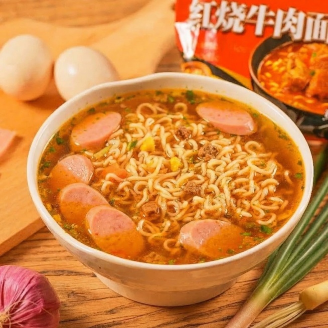 在这碗红烧牛肉面泡面中添加几片粉红色火腿肠，自然融合在汤汁和面条里，保持原图的暖色调和高清写实风格，整体看起来协调自然，更有食欲预览效果
