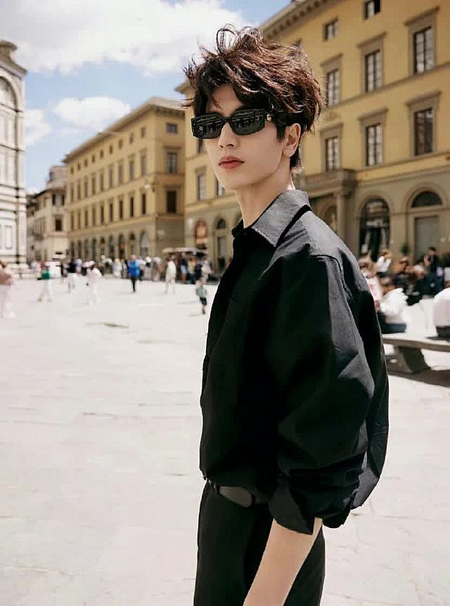 一个男生站在山上，镜头快速拉远，人物急速缩小，展示连绵的山峰大全景。