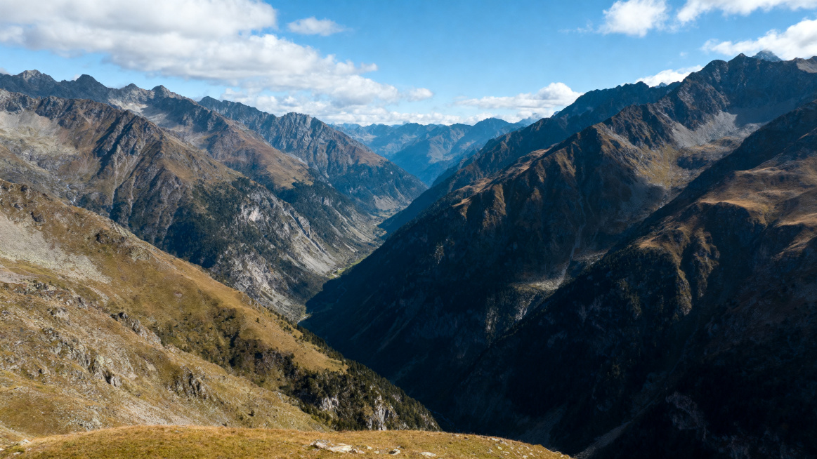 宽幅山区自然风光，展现壮阔的山川气势，层次分明的远景与近景对比，巍峨连绵的山脉，深邃的山谷沟壑，蓝天白云，大气通透，自然风光摄影，史诗级风景画面，画质清晰细腻预览效果