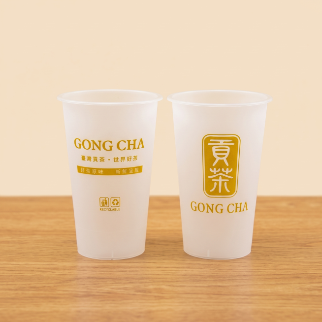 将杯子放置在木色桌子上，背景保持纯色，保留杯子上原有图案和文字并保证其清晰预览效果