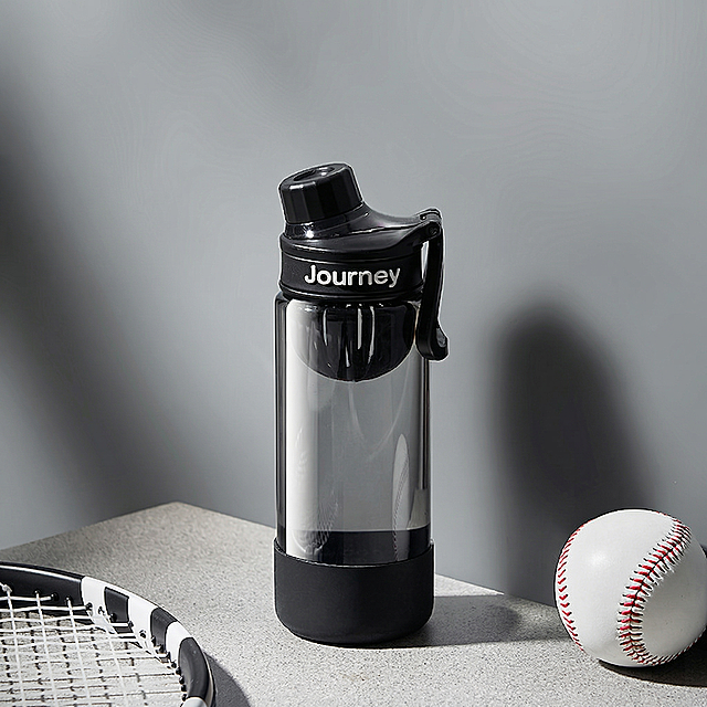 去除黑色水杯杯身的Galaxy文字logo，保持水杯原本的透明质感、原有灰色背景、网球拍和棒球，保留杯盖上的Journey文字logo不做修改，保持原图的构图和光影，画质清晰细节自然，不改变水杯形状和整体结构