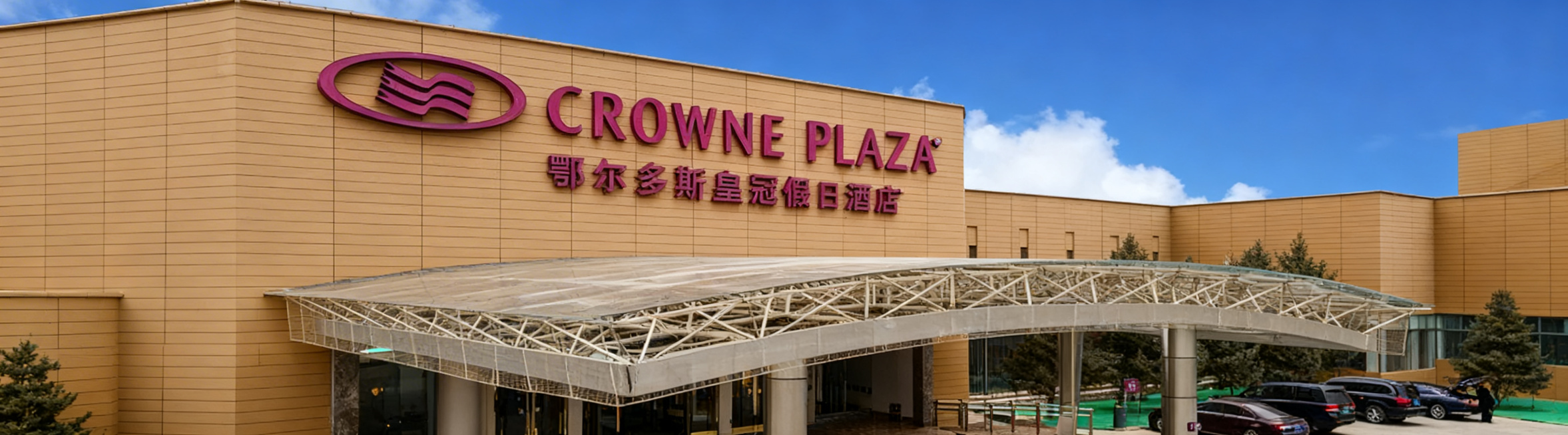 将这张鄂尔多斯皇冠假日酒店门头图片整体压缩适配到360*100像素画布，保留完整酒店门头、品牌logo和所有名称文字，横版构图，保持原有清晰画质和晴朗白天实景氛围预览效果