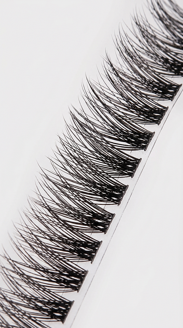 [Main Image 4] Close-up detail display of LC26 segmented false eyelashes. Macro shot showing the fine hair texture, the staggered layered design, and the thin transparent tape base. Show that the lash clusters are soft and fluffy, individual hairs are distinct, lightweight and comfortable. Keep product material characteristics consistent with original. Clean background, soft focused lighting highlights texture. Ratio 9:16, 2K resolution, ultra clear. Negative prompt: deformation, watermark, text disorder, blurred, Chinese characters