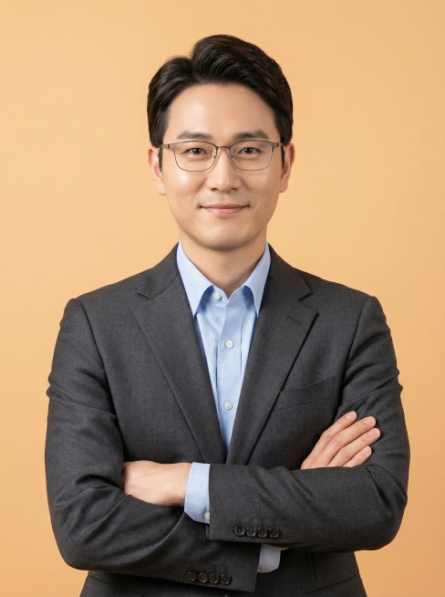 模仿参考照片风格，生成一位男教师证件照，人物正面站立，双臂交叉于胸前，穿着深灰色西装外套内搭浅蓝色衬衫，浅橙色纯色背景，柔和均匀的商业人像布光，突出人物面部预览效果