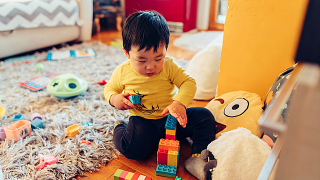 仅将图中儿童的面孔改为典型的亚洲中国特征面孔，将头发改为自然亚洲黑色发色，其余场景、穿着、玩具和构图完全保持不变