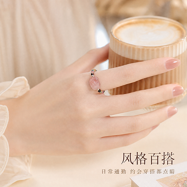[主图-3] 手模佩戴展示图，展现生活化场景与日常百搭风格，营造温柔浪漫氛围。
[统一基调] 雅致ins风，柔和暖光环境，浅米色暖调背景，字体使用纤细优雅的文艺衬线体，主标题字色为深棕褐色，辅助文字为浅棕灰色，文字排版简洁克制。
[画面] 一只皮肤白皙纤细的女性手模，手指修长，佩戴着小碧玺貔貅戒指，戒指戴在中指或食指上，位置清晰可见。手轻轻捏着一杯透明玻璃杯装的拿铁咖啡，咖啡表面有细腻奶泡，或者手指轻轻搭在一本米白色封面的书本上，展现生活化的日常场景。手部姿态自然放松，美甲为淡粉色或裸色简约款式，干净优雅。背景为虚化的室内环境，有柔和的暖光从侧方照射，营造温柔浪漫的氛围。戒指在手指上清晰展示，草莓晶貔貅和多彩碧玺珠子都清晰可见，与手部自然贴合。
[光影质感] 生活方式摄影质感，柔和暖光，皮肤质感细腻，宝石有自然光泽，背景虚化形成漂亮的散景，整体氛围温暖治愈。
[配色] 暖米色整体色调，深棕褐色标题字，浅棕灰色辅助文字，手部肤色自然白皙，戒指多彩宝石点缀其中。
[文字版式] 画面右下角或左下角留白处，主标题："风格百搭"，下方小字："日常通勤 约会穿搭都点睛"。文字字号适中，不遮挡手部和戒指主体。
[输出要求] 1:1正方形，1440x1440像素，手部和戒指清晰，文字可读，氛围温柔。负向：手部畸形、手指数量异常、戒指穿模、错字、模糊、水印、平台Logo、过度磨皮失真。