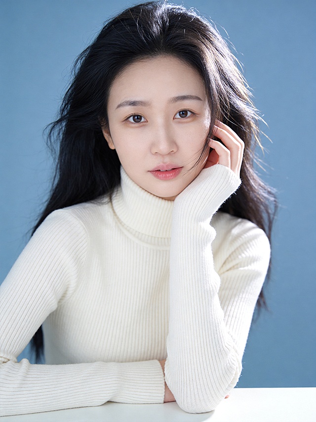 清新温柔风治愈系人像写真,传递纯净松弛的日常氛围感;人物主体:眼神清澈直视镜头(眼神灵动带软萌感,粉橘色唇釉修饰的嘴唇微张),(发丝蓬松有自然空气纹理,右侧发丝轻垂脸颊),清透伪素颜妆(浅棕色眼影自然晕染眼窝,细内眼线放大双眼,底妆轻薄通透保留皮肤原生质感);环境与构图:纯净莫兰迪浅蓝纯色背景,无任何干扰元素,近景取景(覆盖头顶至腰部上方,精准突出面部神态与上半身柔和线条),三分构图(人物面部落在画面左侧1/3与上方1/3交汇点,人物面部为绝对视觉焦点),平拍视角(镜头高度与人物眼部完全平齐,拉近距离增强亲近感);光影与色彩:柔光主光从右侧45°侧方照射,5500K冷白柔光,光线强度柔和不刺眼,发丝边缘形成细腻金边高光,面部光影过渡自然丝滑(柔和阴影轻描下颌线,额头､鼻梁､苹果肌处的高光提亮面部立体感),低饱和度莫兰迪蓝+米白为主色调,低对比度搭配让色彩清新柔和不突兀;细节补充:身着米白色高领针织衫(细腻羊毛肌理清晰可见,修身款式完美贴合身形曲线,高领柔软贴合颈部无紧绷感),动作姿态为右手抬起轻触右侧脸颊,手肘自然支撑在身前平面,身体微侧左肩稍向前,肢体姿态松弛无刻意感;人物居中位于画面中心;氛围与画质:清新柔光氛围滤镜(曝光+3,对比度,8,自然通透感拉满),超高清4K分辨率,中度锐化处理(清晰呈现每一缕发丝纹理､针织衫的细腻肌理以及面部皮肤的通透质感),纯净无噪点,整体画面质感细腻高级,传递出松弛治愈的温柔气质｡