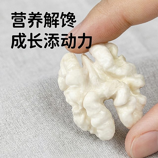 两根手指捏着一块完整的去皮核桃仁，保持手指握持姿势、产品形态和文字内容“营养解馋 成长添动力”位置不变，替换原浅白色模糊背景为真实干净的浅灰色亚麻布料背景，整体明亮柔和自然漫射光，突出核桃仁新鲜乳白水润质感，商业美食摄影风格，保持1:1正方形画面。