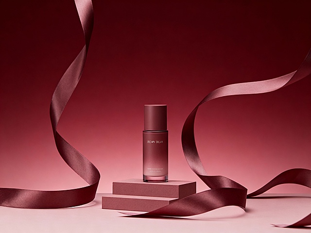 暗红色渐变背景，背景有豆沙色丝带缠绕，小台阶上放置产品，产品呈现前后层次感，光线柔和，整体氛围温馨雅致