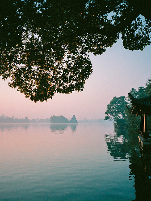D组：高维秩序（精致与格调）
上海 (Shanghai)： The Bund view from a luxury window, rain droplets on glass, city lights bokeh in background, cool blue and gold tones, jazz vibe, cinematic, shot on Kodak Portra 400 --ar 3:4 --style raw

香港 (Hong Kong)： Hong Kong retro street, neon signs reflecting on wet pavement, Wong Kar-wai film style, moody green and red colors, cinematic atmosphere, shot on Kodak Portra 400 --ar 3:4 --style raw

杭州 (Hangzhou)： West Lake at sunrise, soft mist over water, pagodas in distance, zen and peaceful, gentle warm light, minimalist composition, shot on Kodak Portra 400 --ar 3:4 --style raw

天津 (Tianjin)： Tianjin European style architecture, Tianjin Eye ferris wheel in distance, warm sunset glow, romantic vintage movie feel, shot on Kodak Portra 400 --ar 3:4 --style raw

E组：灵性深海（自由与呼吸）
厦门 (Xiamen)： Xiamen seaside road, palm trees swaying, blue sea at twilight with warm street lights, peaceful island vibe, film photography, shot on Kodak Portra 400 --ar 3:4 --style raw

扬州 (Yangzhou)： Yangzhou willow trees by the river, misty rain, soft green tones, poetic traditional Chinese painting aesthetic, quiet and calming, shot on Kodak Portra 400 --ar 3:4 --style raw

阿那亚 (Aranya)： Aranya lonely library by the sea, blue hour sky, warm light coming from inside the building, peaceful solitude, minimal composition, shot on Kodak Portra 400 --ar 3:4 --style raw

青岛 (Qingdao)： Qingdao red roofs and blue ocean, golden sunset light, refreshing summer breeze vibe, vintage film look, bright and airy, shot on Kodak Portra 400 --ar 3:4 --style raw