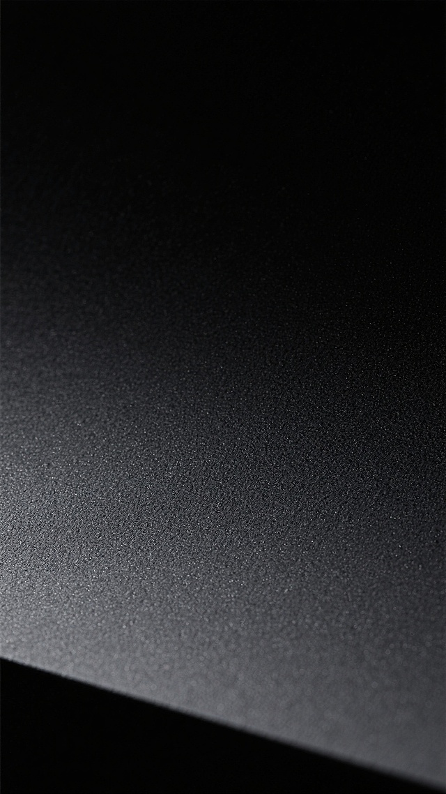 深黑色背景，具有细腻均匀的磨砂质感纹理，整体呈现出沉稳内敛的哑光效果，表面带有细微的颗粒感，光线照射下边缘有极淡的渐变过渡，营造出简约而高级的视觉氛围。