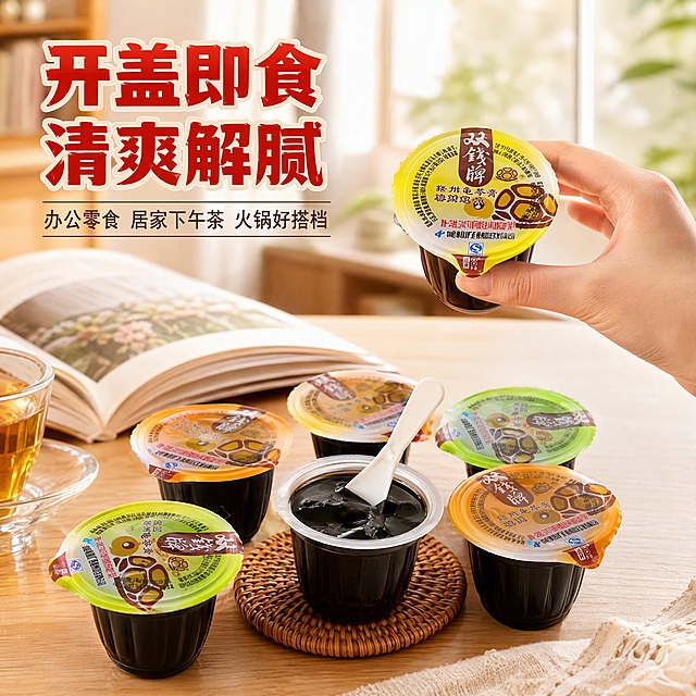 [主图-4] 场景与体验，展示家庭/办公即食场景，增强代入感。
[统一基调] 淘宝/天猫食品主图风格，专业品质感，国潮食欲风；背景主色暖棕红渐变搭配浅米白，标题字色为朱红+米白描边，辅助字色深棕，强调色金黄；字体为粗厚国潮黑体，标题粗重醒目，辅助文字纤细清晰；整体满版无边框构图，自然暖阳逆光，画面通透有食欲。
[画面] 温馨的居家餐桌场景，浅木色餐桌上摆放着几杯双钱牌龟苓膏啫喱杯，其中一杯已打开插着小勺子，旁边有一本翻开的书和一杯清茶，营造休闲下午茶氛围；一只手（仅手部，不露脸）正拿起一杯龟苓膏，动作自然；背景是虚化的明亮客厅或书房，有柔和的自然光从窗户照入；产品占画面约50%，视角为45度平视，场景真实生活化。
[光影质感] 自然窗边柔光，整体明亮温暖，桌面有柔和倒影，啫喱杯有真实的环境反光，手部光影自然，整体生活摄影质感。
[配色] 整体暖木色+米白色调，温馨明亮，产品包装色彩鲜明突出，标题朱红在浅背景上清晰醒目。
[文字版式] 画面左上方主标题“开盖即食 清爽解腻”，下方小字“办公零食 居家下午茶 火锅好搭档”；文字简洁，不遮挡产品和手部动作，放在左上角空白区域。
[输出要求] 1:1正方形比例，2048px分辨率，文字清晰无错字，产品外观与原图一致，场景自然真实，手部正常无畸形，无水印无平台Logo，禁止出现人物面部。