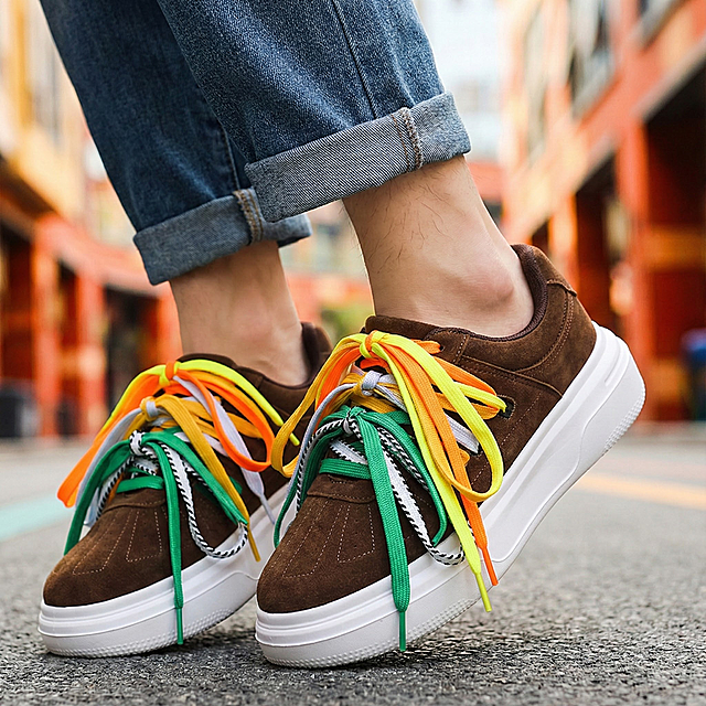 把这双男生板鞋穿在一个年轻小伙子脚上，小伙子穿着牛仔裤，没有穿袜子