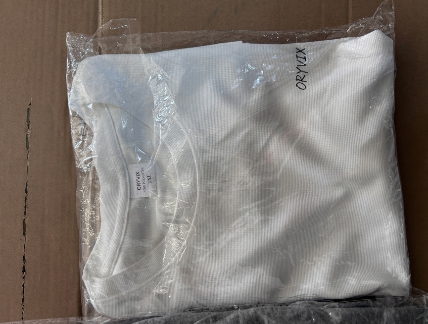将图片上所有的原有英文替换成ORYVIX，包括领口标签上的KEHETSOFT和包装上竖排的KEHETSOFT，都替换为ORYVIX，保留原图整体构图、包装透明质感和白色T恤的状态，超清画质，保留细节预览效果