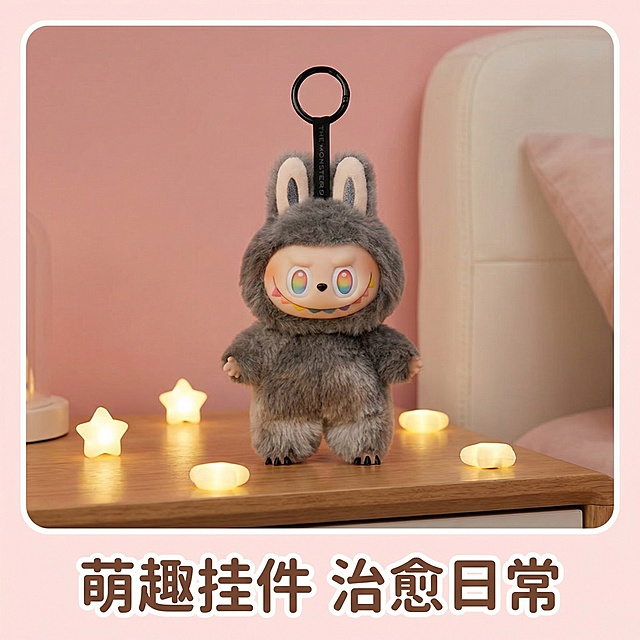 将图中灰色隐藏款毛绒挂件放置在温馨卧室床头场景中，背景为浅粉色墙面搭配白色软包床头，周围散落星星小夜灯，突出产品可爱治愈风格，底部添加“萌趣挂件 治愈日常”文案