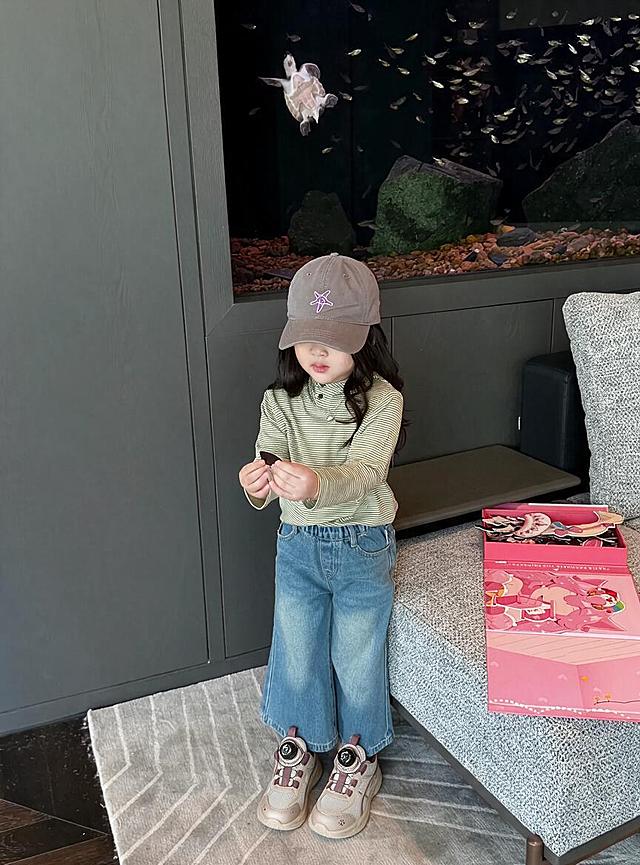 将图中人物脚上的鞋子替换为第一张图中的米白紫配色旋钮扣儿童运动鞋，保持人物姿势、服装、背景和整体画面风格不变，鞋子角度和透视与脚部姿态自然匹配，光影真实自然